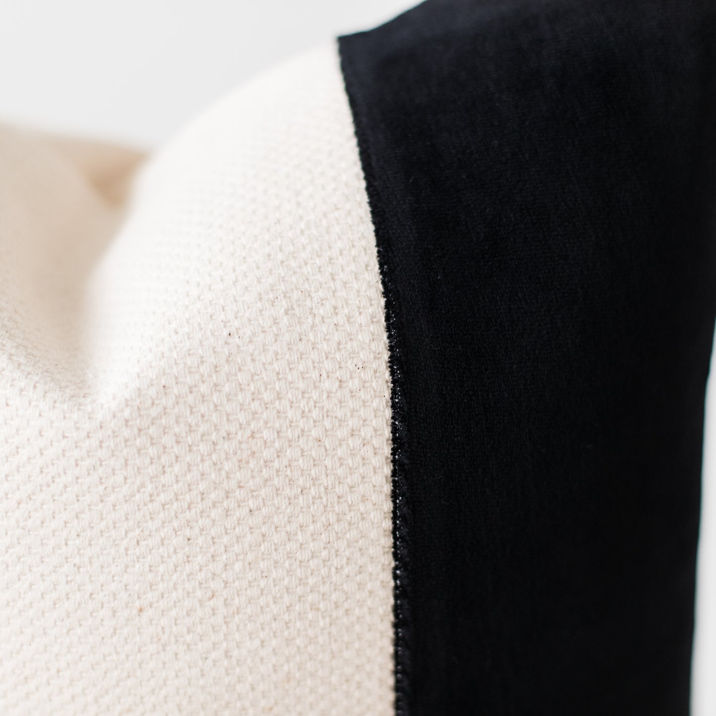 Close-up of cream and black textured fabric showing weave detail and color contrast.