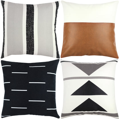 Four decorative pillows: striped gray/black/white, cognac leather, black with white dashes, and cream with geometric triangle