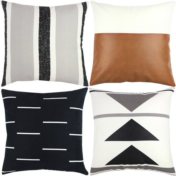 Four decorative pillows: striped gray/black/white, cognac leather, black with white dashes, and cream with geometric triangle