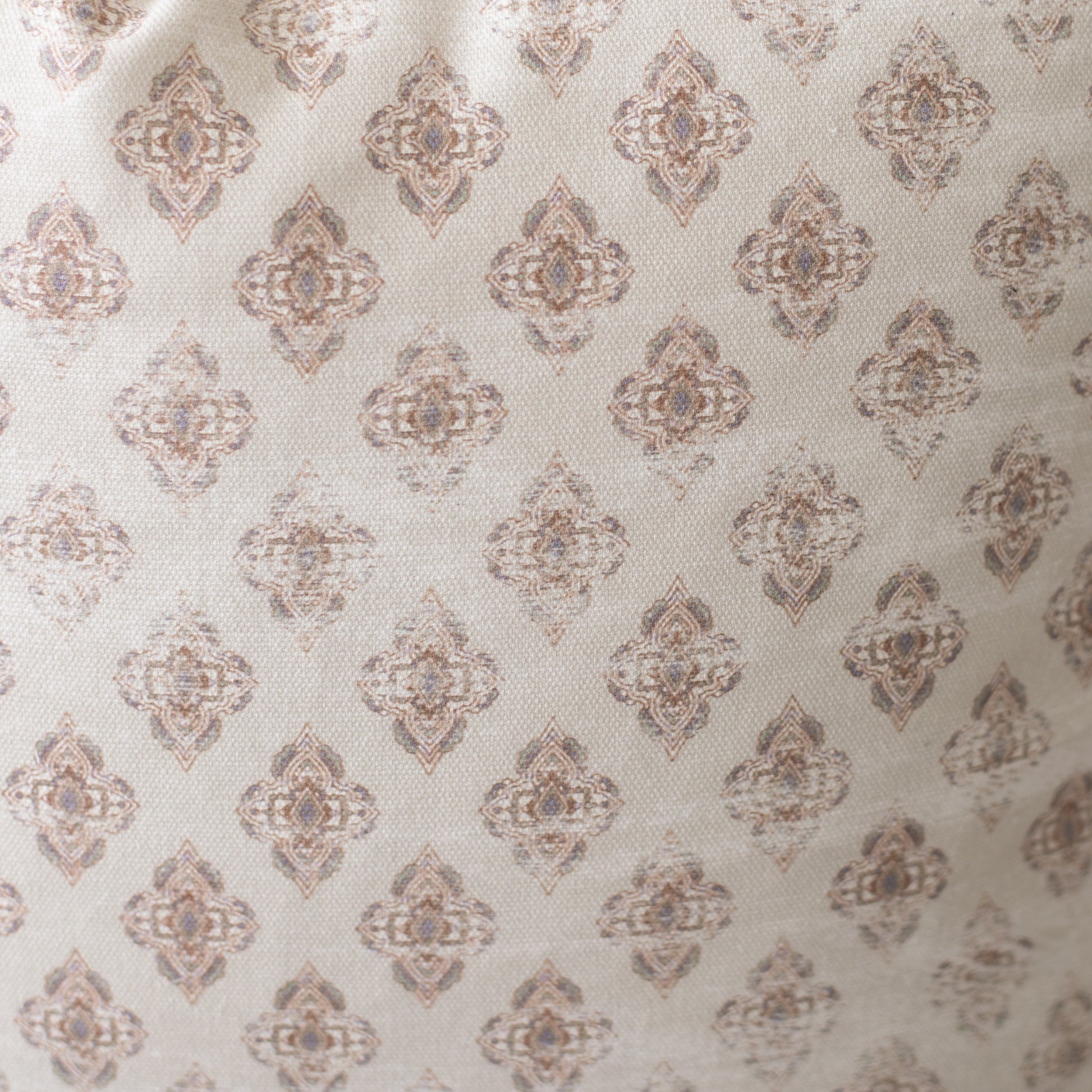 Four cream pillows with repeating taupe geometric diamond medallion pattern.