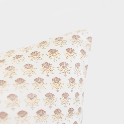 White lumbar pillow with repeating tan and mauve floral pattern throughout.