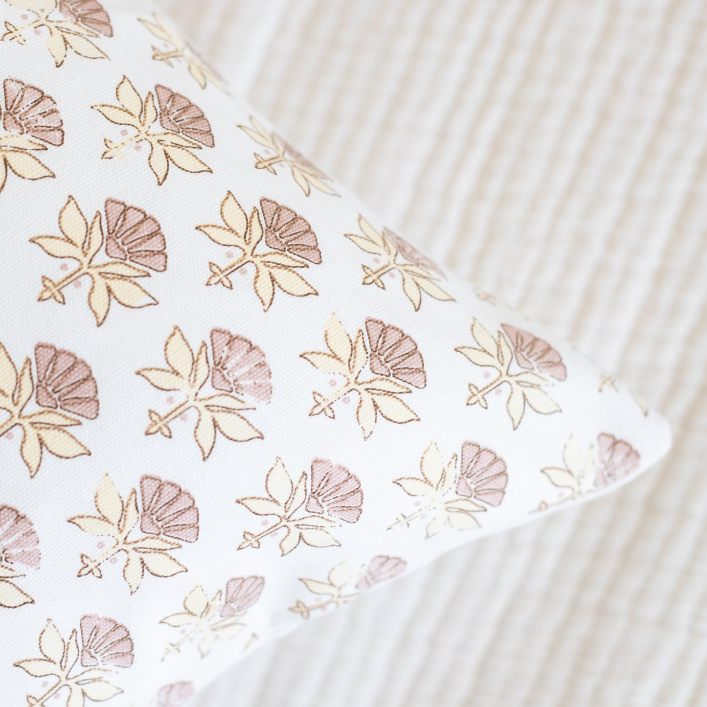 White fabric with tan and mauve floral pattern featuring fan-shaped flowers and leaves.