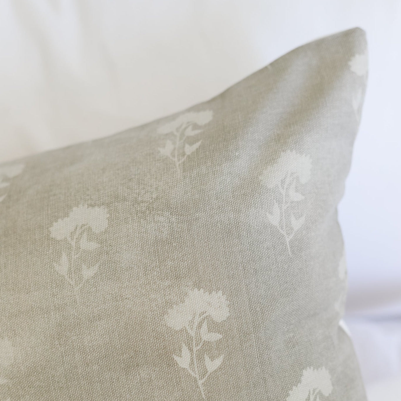 Gray lumbar pillow with white floral pattern and woven fabric texture.