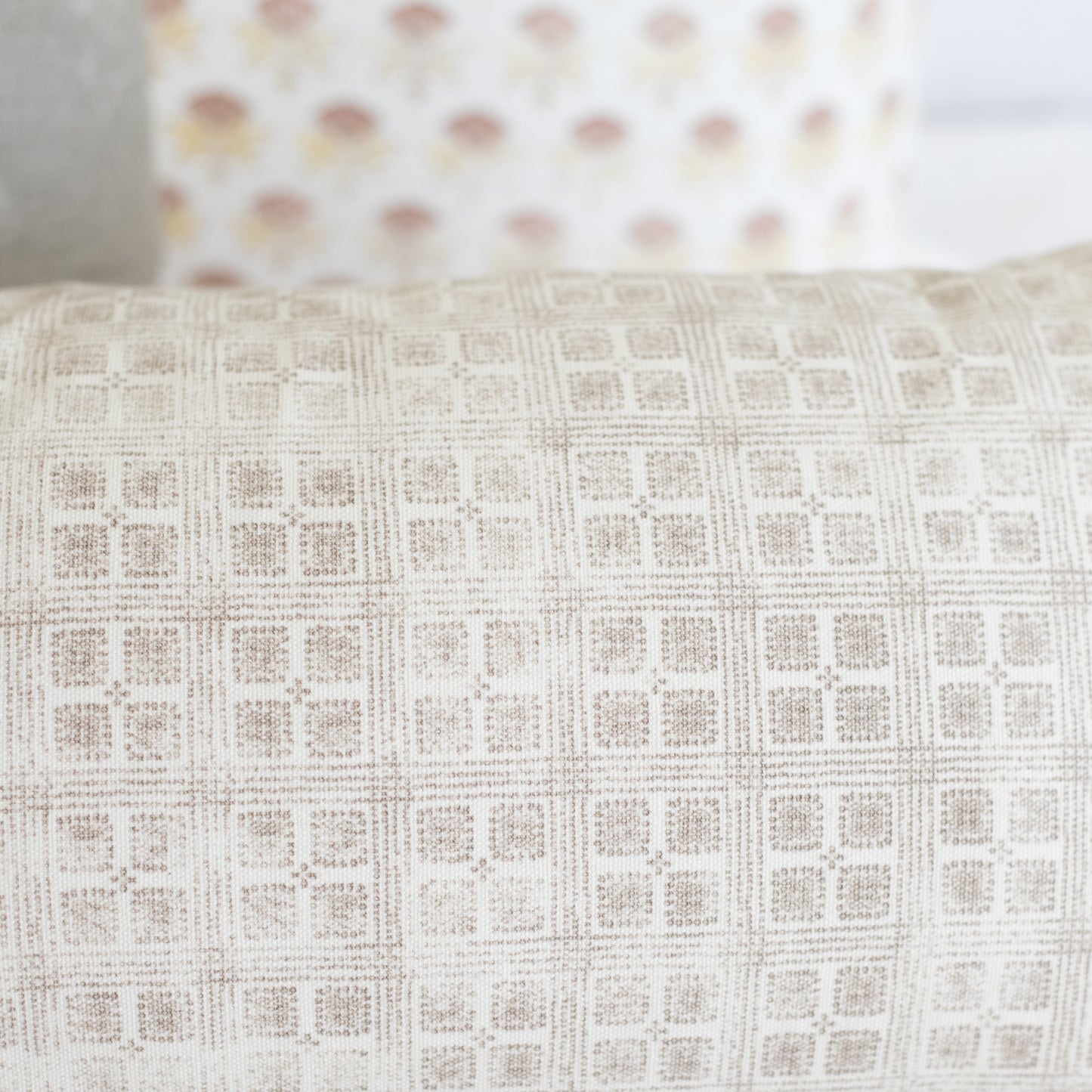 Rectangular lumbar pillow with cream and beige grid pattern texture.