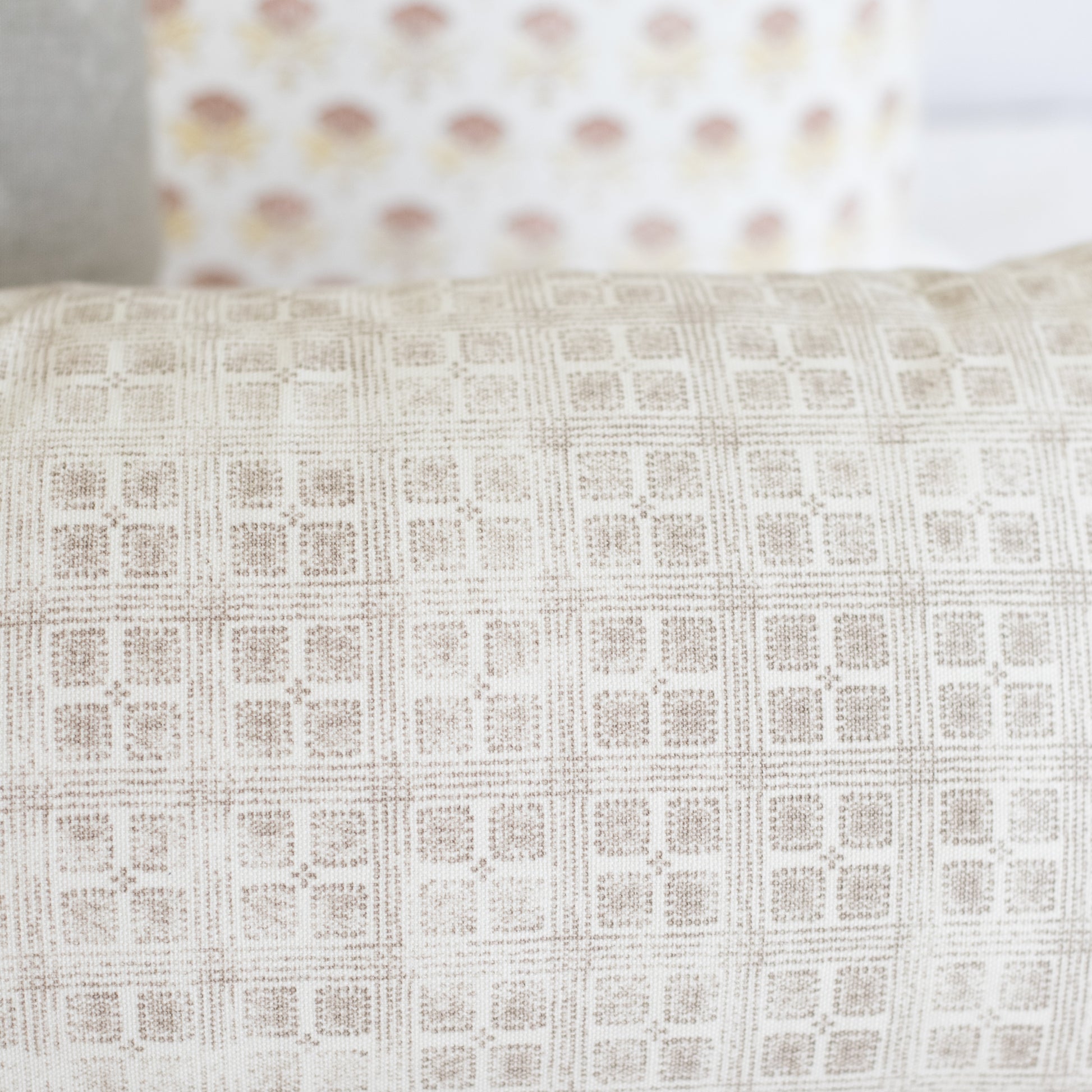 Rectangular lumbar pillow with cream and beige grid pattern texture.