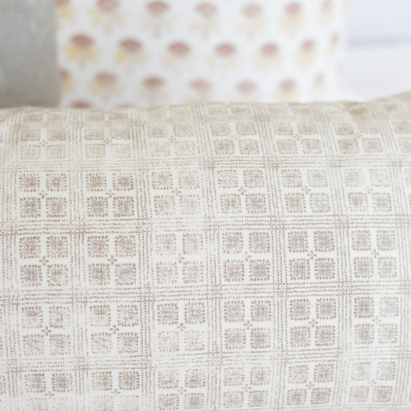 Rectangular lumbar pillow with cream and beige grid pattern texture.