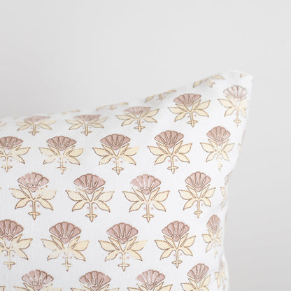 White pillow with repeating tan and brown line-drawn floral motifs arranged in rows.
