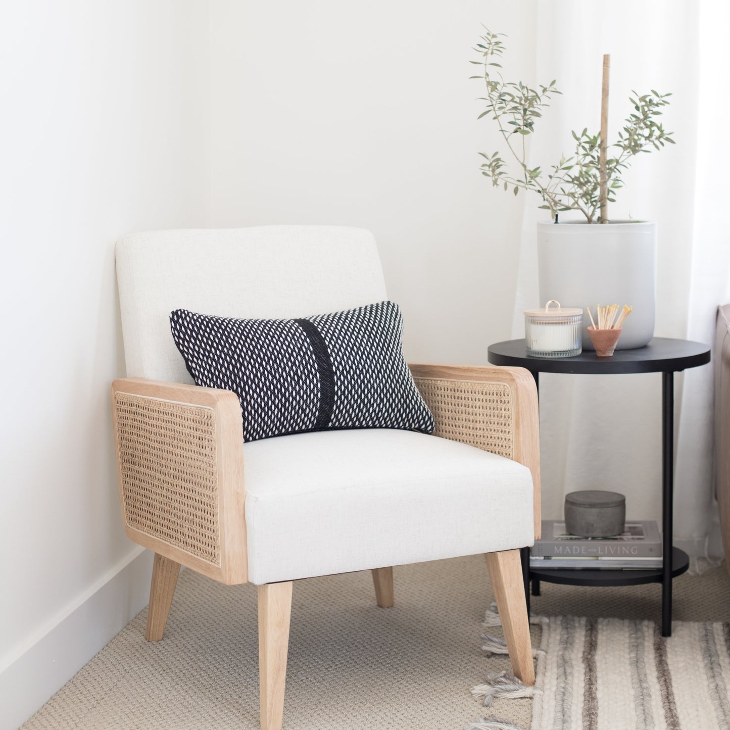Navy and white geometric patterned lumbar pillow with stripe detail displayed on a mid-century modern chair.