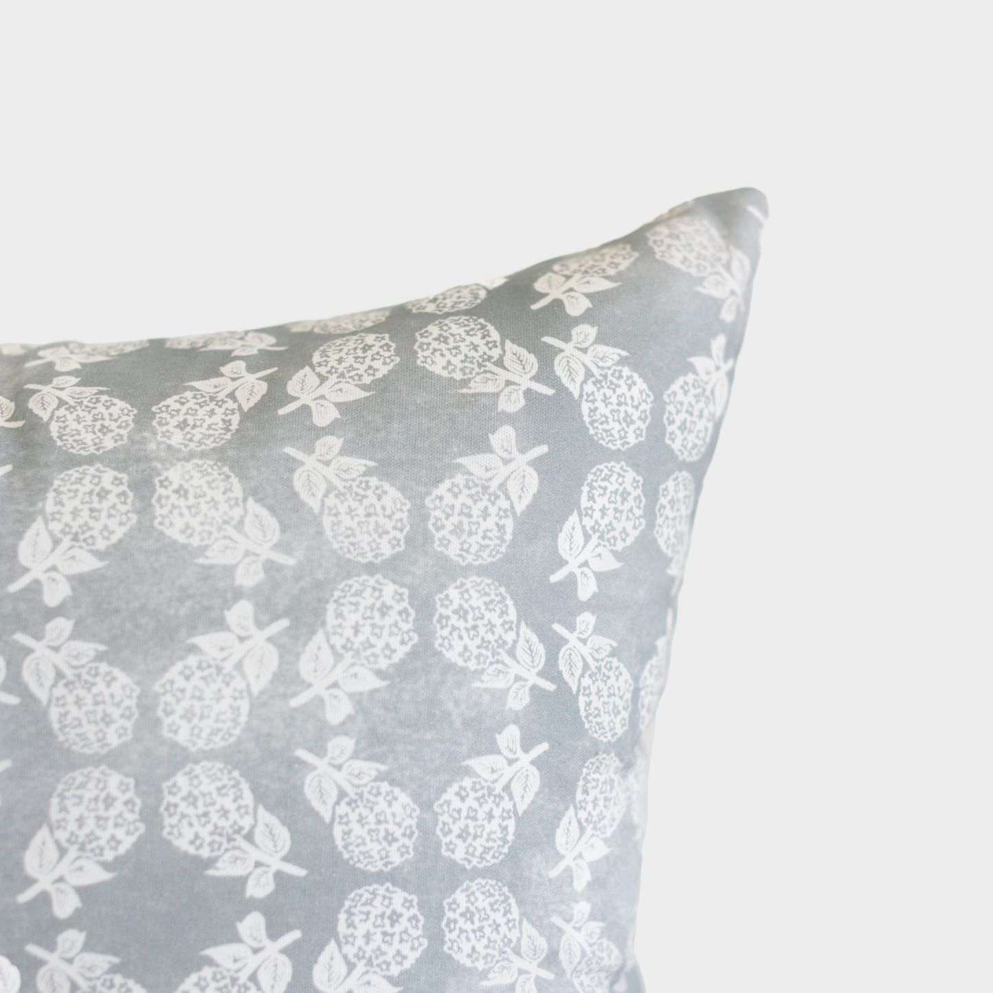 Gray cushion cover with white strawberry and leaf pattern.