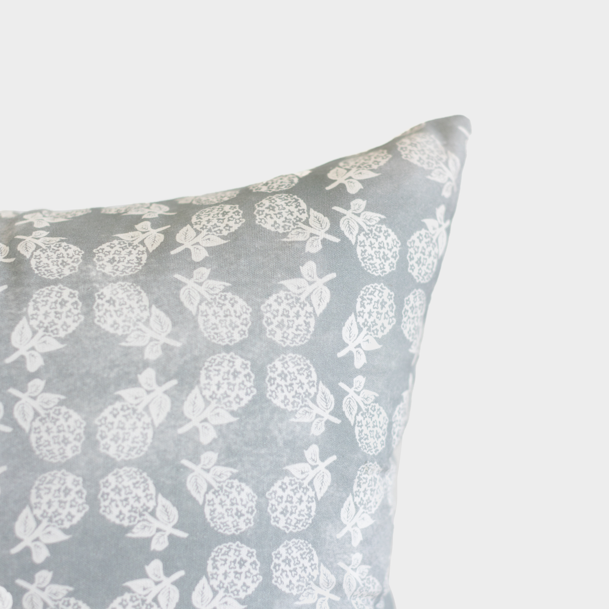Gray cushion cover with white strawberry and leaf pattern.