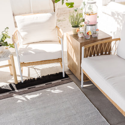 Gray and white geometric patterned outdoor rug with black border stripe.