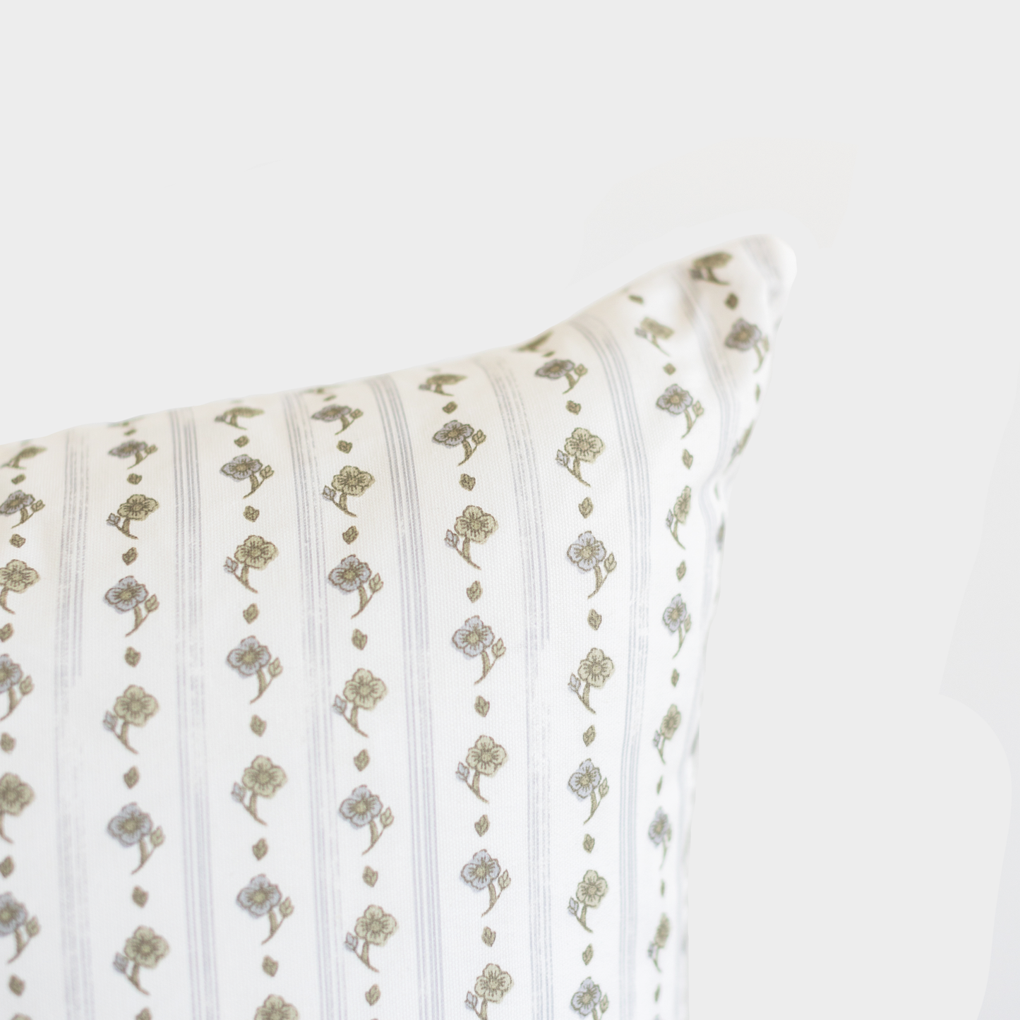 Cream lumbar pillow with sage green vertical stripes and floral motifs in alternating pattern.