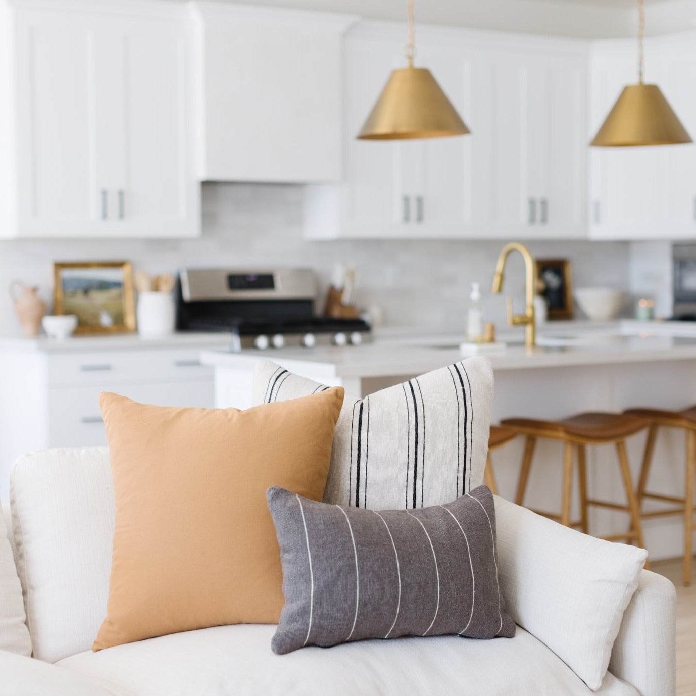 Terracotta solid-colored square and rectangular throw pillows in various sizes displayed on a white sofa.