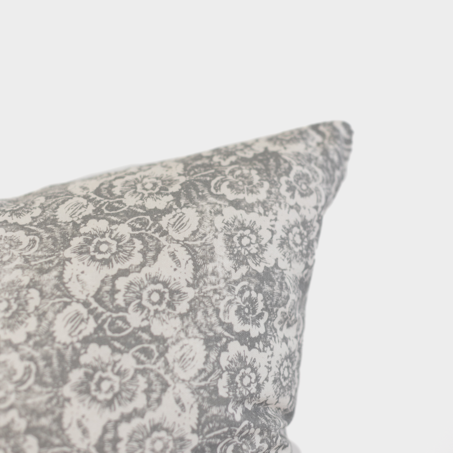 Gray and cream floral patterned pillow with detailed botanical print design.
