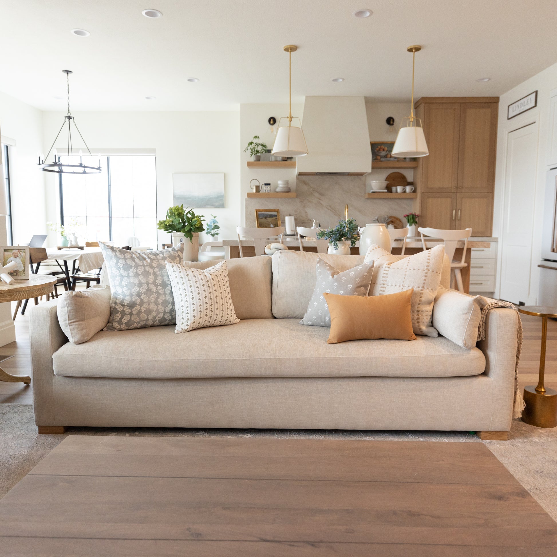 Terracotta-colored rectangular area rug placed on hardwood floor in front of beige sofa in living room.