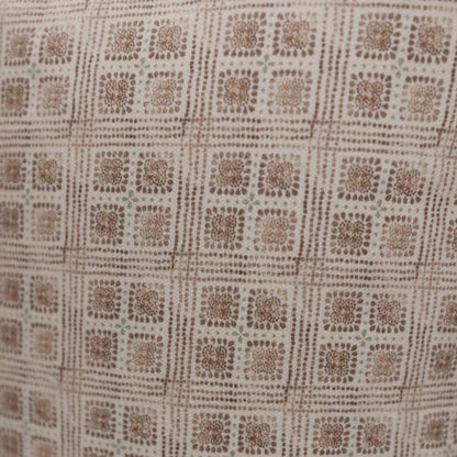 Brown and cream lumbar pillow with geometric grid pattern of textured floral squares.