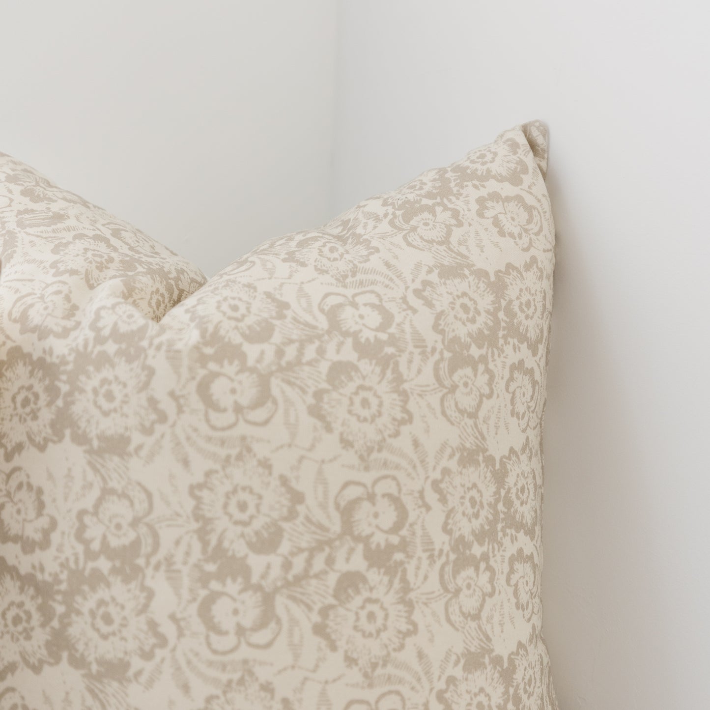 Cream pillow cover with taupe damask floral pattern, shown in corner detail view.
