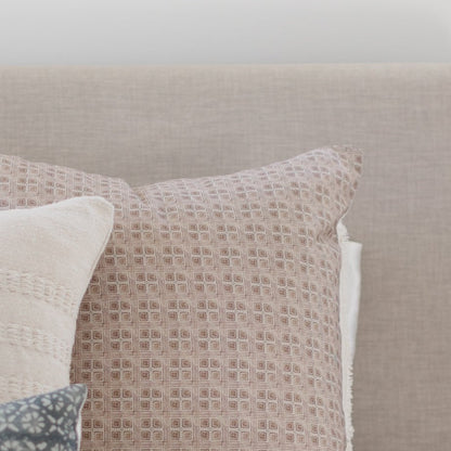 Brown and cream grid patterned pillow with textured weave fabric displayed against neutral background.