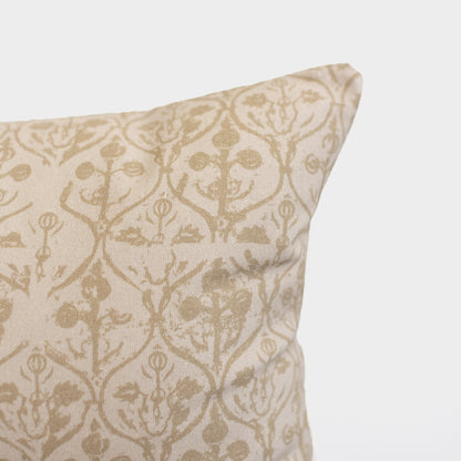 Cream and tan floral patterned pillow with symmetrical botanical design and decorative ornamental details.