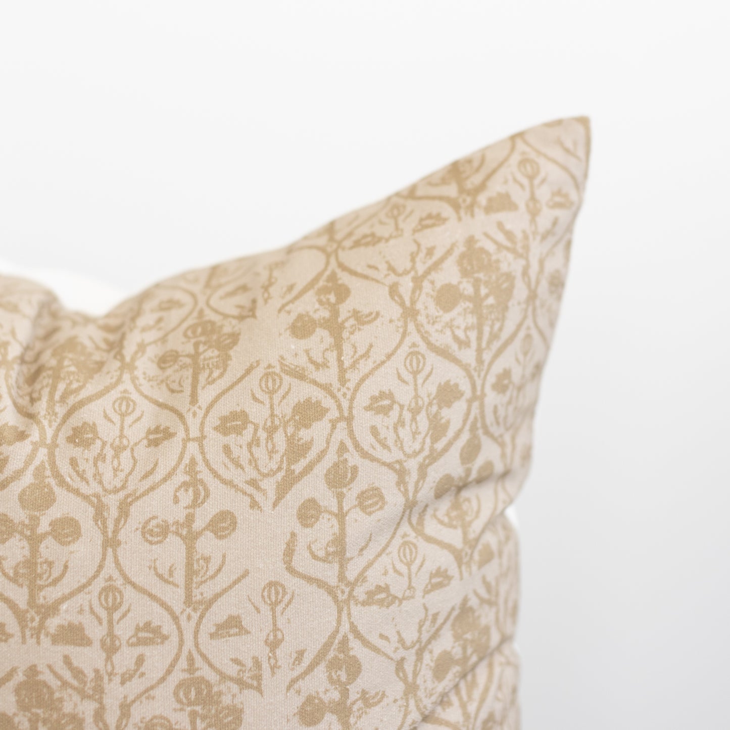 Beige pillow cover with tan floral and geometric damask pattern throughout.