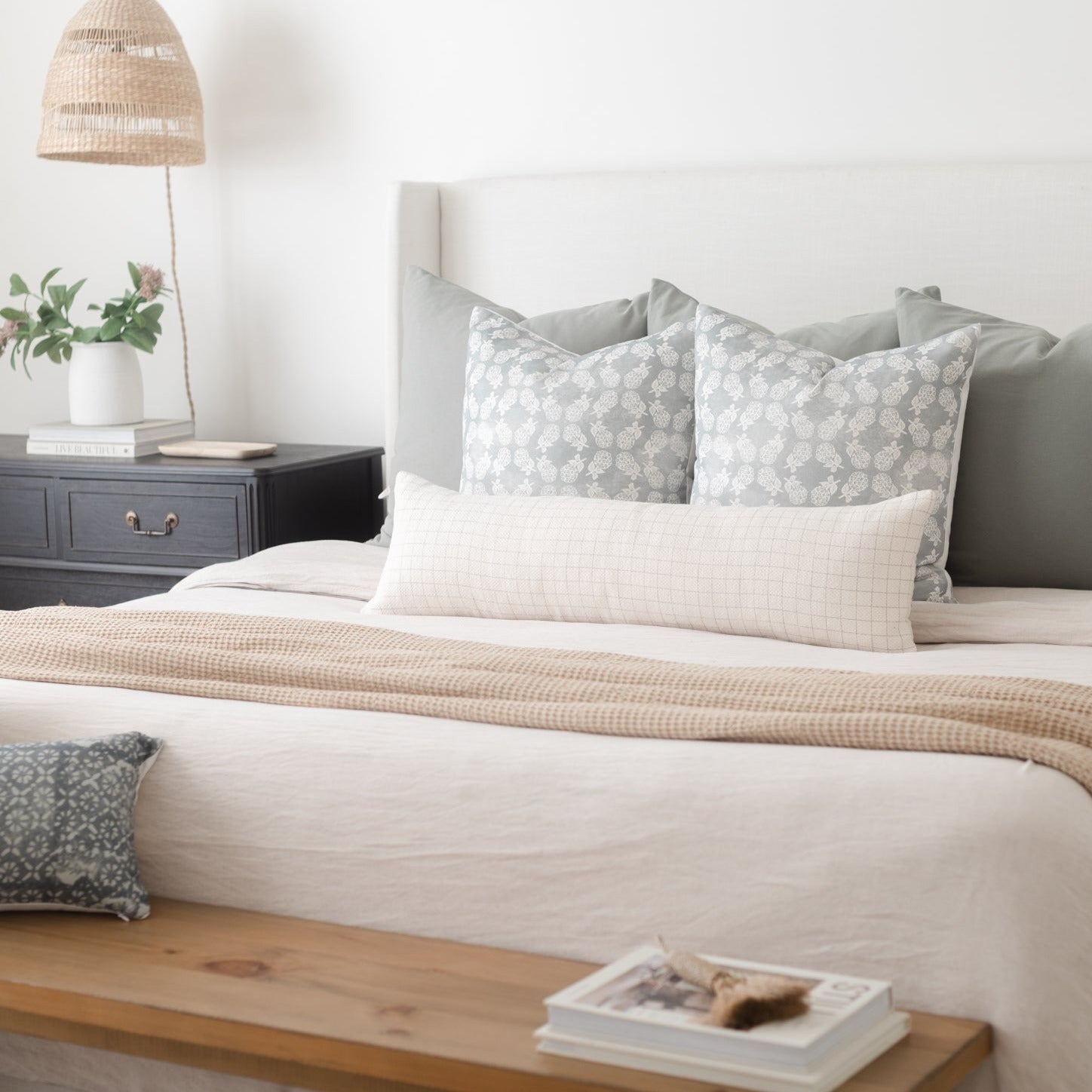 Rectangular lumbar pillow with geometric grid pattern in gray and white, displayed on bed with matching bedding.
