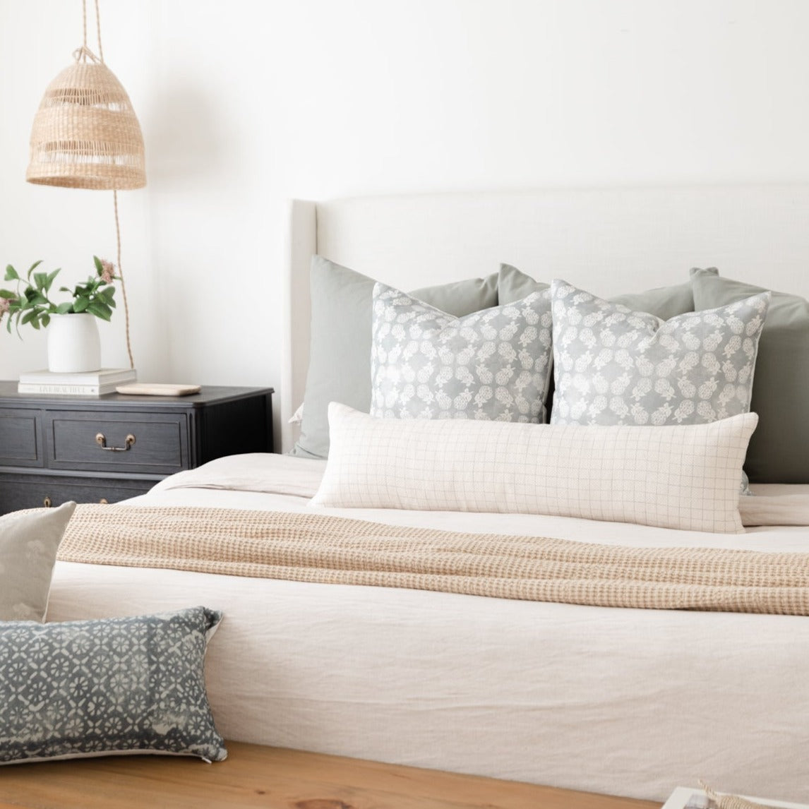 Lumbar pillow with geometric grid pattern in gray and white, displayed on bed with coordinating bedding.