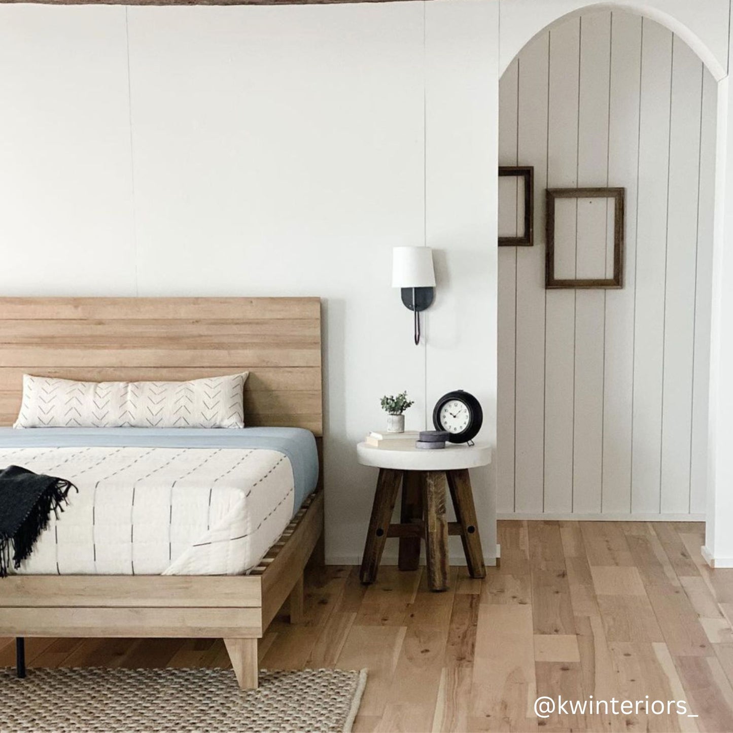 Cream lumbar pillow with geometric pattern displayed on wooden bed in modern bedroom setting.