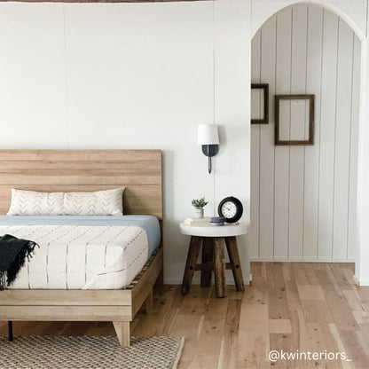 Cream lumbar pillow with geometric pattern displayed on wooden bed in modern bedroom setting.